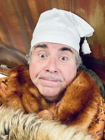 Photographie en coulisses : détail du bonnet blanc et du costume